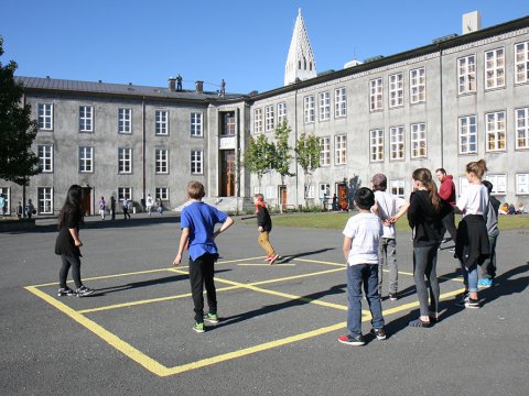 Children playing pogo on the grounds of Austurbæjarskóli.