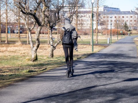 Kona á rafhlaupahjóli á göngustíg í miðborg Reykjavíkur.