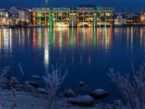 Ráðhúsið lýst með jólaljósum og frost yfir Tjörninni.