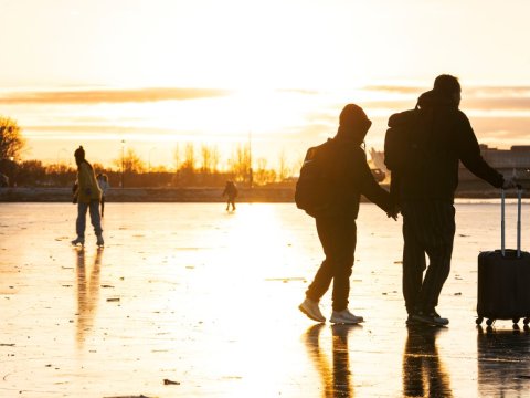 Fólk gengur yfir ísi lagða Tjörnina í Reykjavík. 