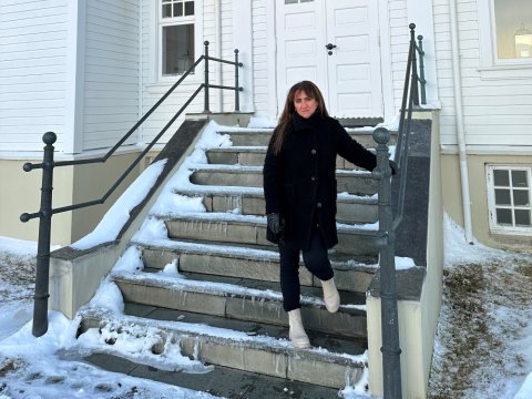 Anna Karen Kristinsdóttir, móttökufulltrúi Reykjavíkurborgar, stendur í tröppunum við Höfða. Svartklædd, heldur í handriðið. Snjór og kalt úti.