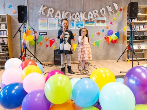 Tvö börn syngja í krakkarokki í Ævintýrahöllinni 2023, barnamenningarhátíð, blöðrur í forgrunni.