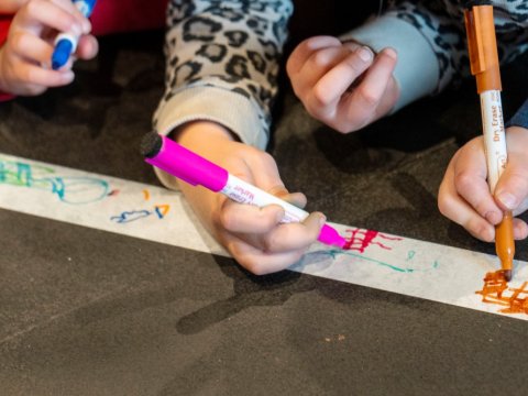 Children in preschool drawing with markers