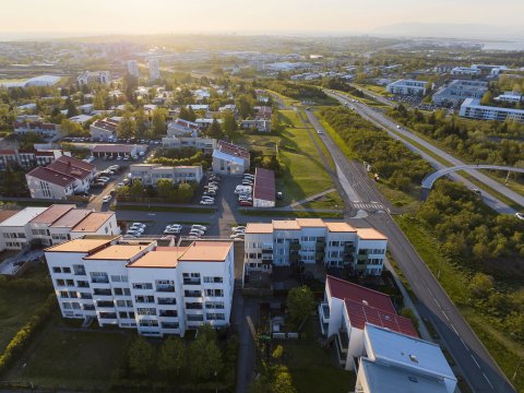 Loftmynd af Breiðholti, borgin og sólarlag í baksýn