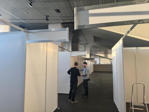 Two men examine drawings in Tjarnarsalur where voting booths are being set up