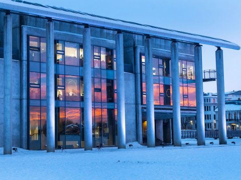 Ráðhús Reykjavíkur, sólarlag speglast í rúðum hússins. 