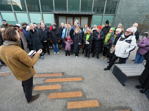Frá afhjúpun ljóðlistaverks Sigurðar Pálssonar við Tollhúsið. Margmenni stendur í hálfhring og hlustar á Ragnar Helga Ólafsson rithöfund tala.