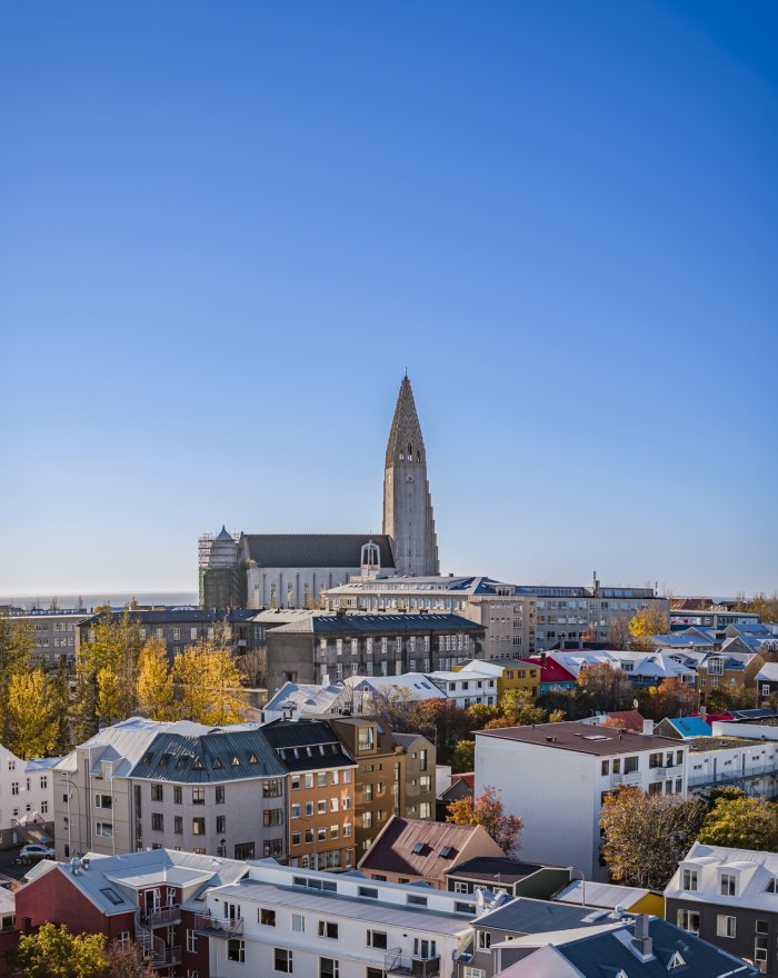 Mynd af húsum og Hallgrímskirkju. Blár himinn.