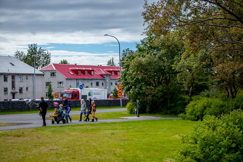 Klambratún í átt að miklubraut. Fjölskylda gengur eftir göngustígnum