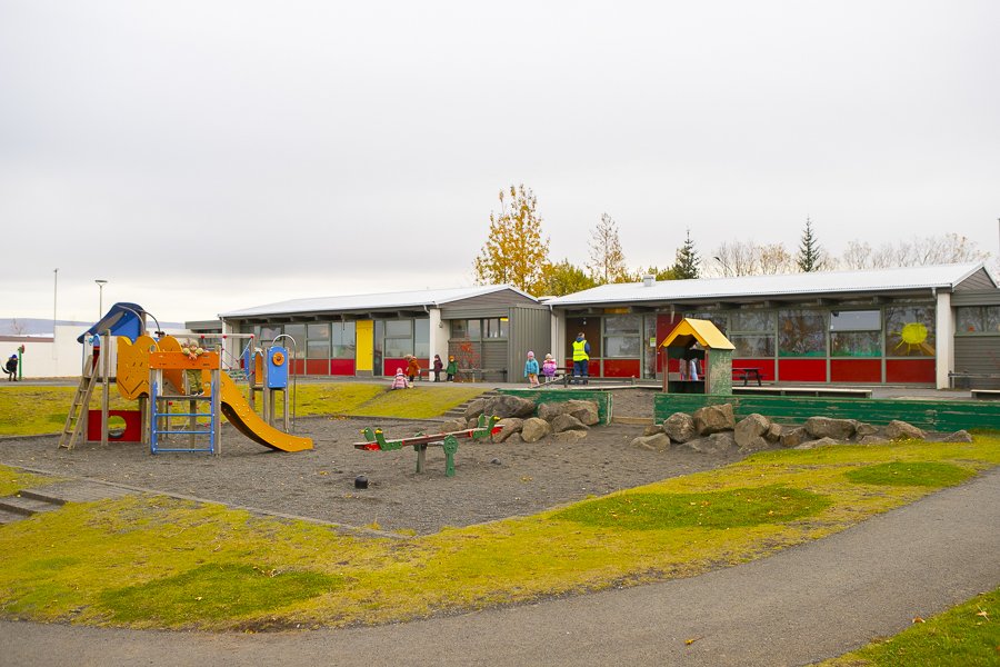 Leiksvæði leikskólans Borg / Arnarborg og húsið í baksýn