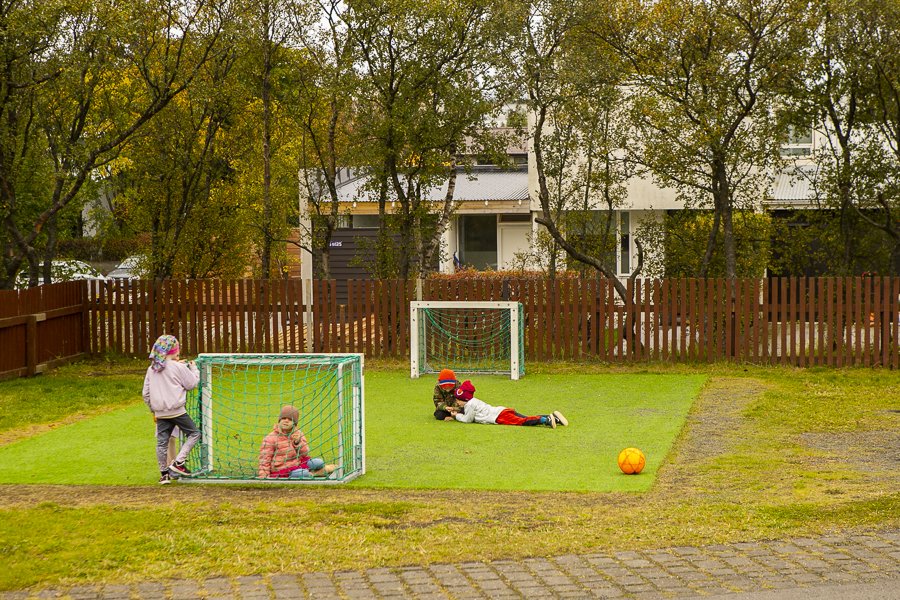 Börn í fótbolta á lóð Austurborgar.