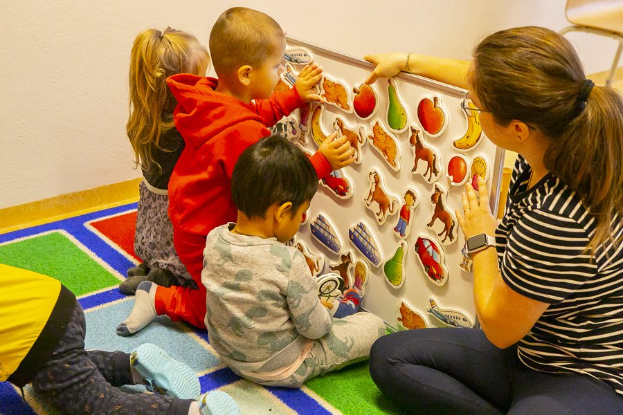 Children playing with a preschool teacher at Bakkaborg.