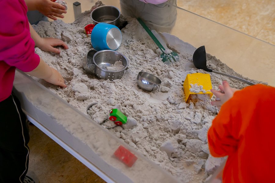 Children playing at an indoor sand table at Blásalir.