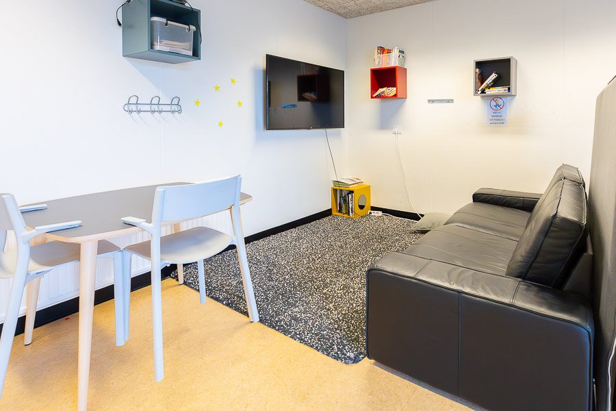 Sofa in front of television on wall. 