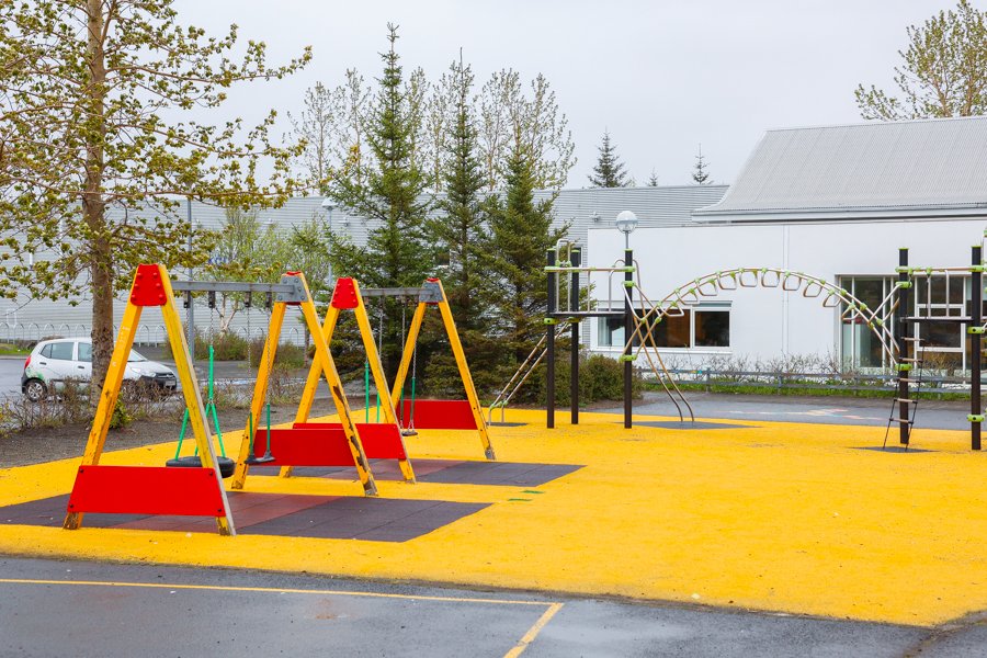 Seesaws and a jungle gym on yellow surface. 