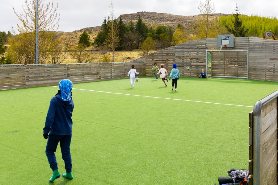 Children playing soccer on an outdoor field.