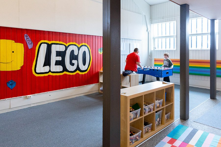 Hall at the Frostheimar after-school program with a foosball game, Lego logo painted on the wall and a Rainbow Flag.