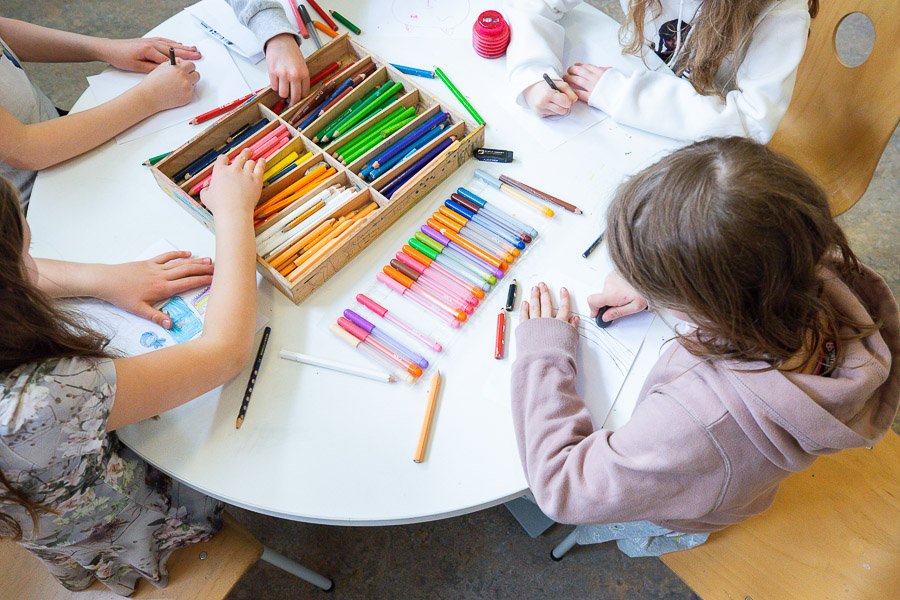 Children color at a table.