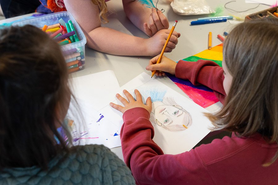 Children at a table coloring pictures.
