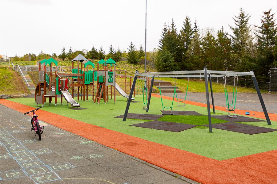 A playground castle and seesaws on the school grounds.