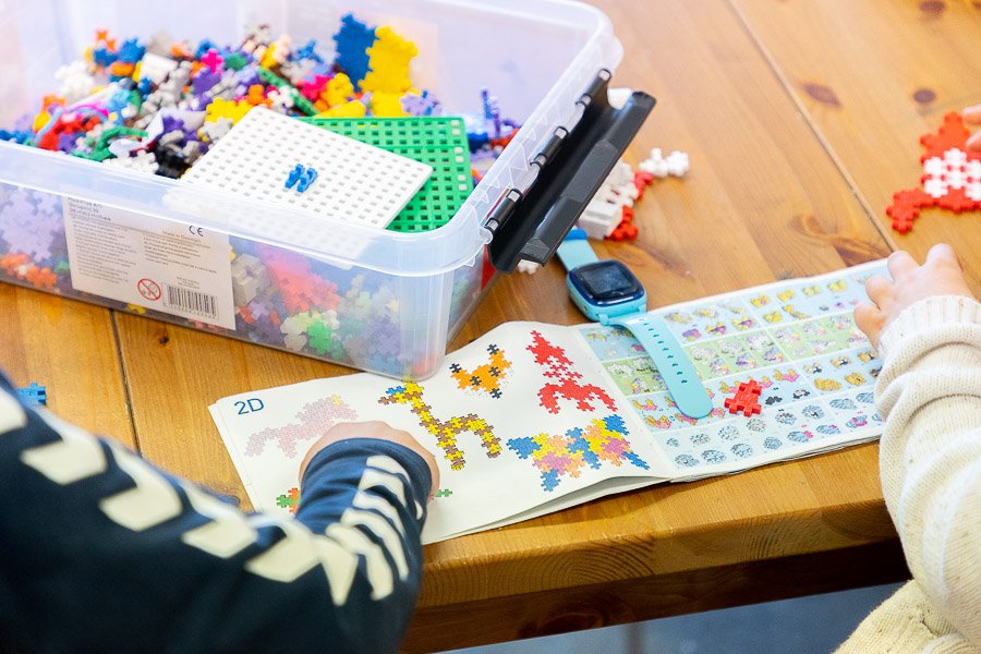 Children at a table building with Lego blocks.