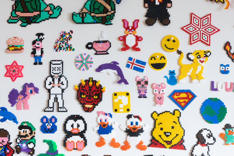Figures made from Perler beads on a wall.