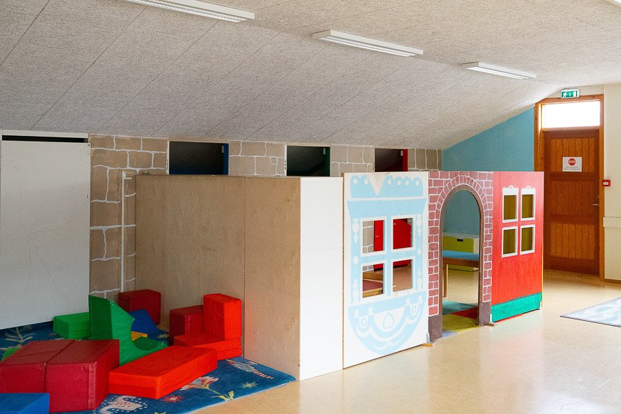 Small house for children to play in and rug with pillows at Laugarsel after-school program.