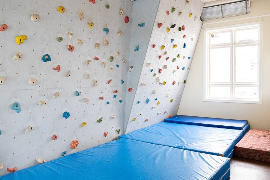 Climbing wall and mats at Laugarsel after-school program.