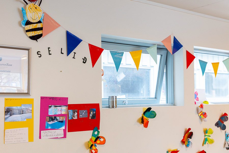 Wall decorated with butterflies, a ladybug and bunting created by children at Selið after-school program. 