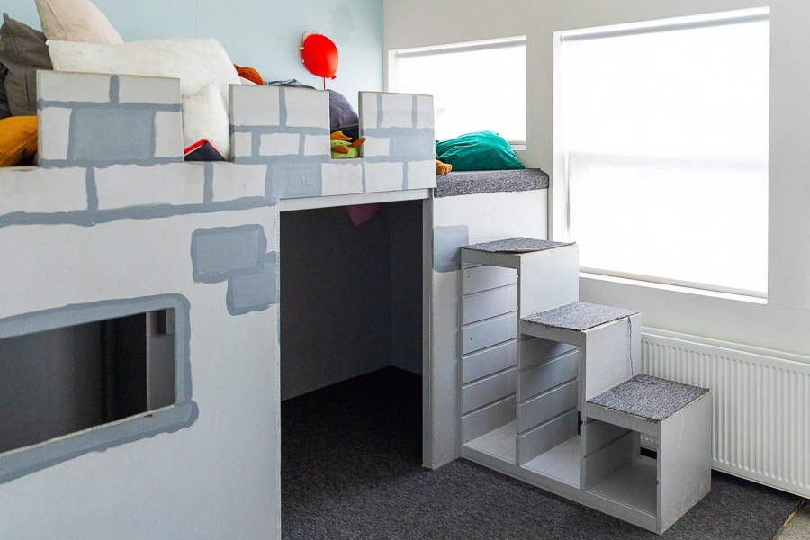 Walls and stairs leading up to a cozy area decorated as a castle.
