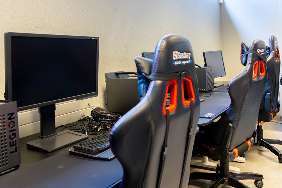 A long table with computers and office chairs. 