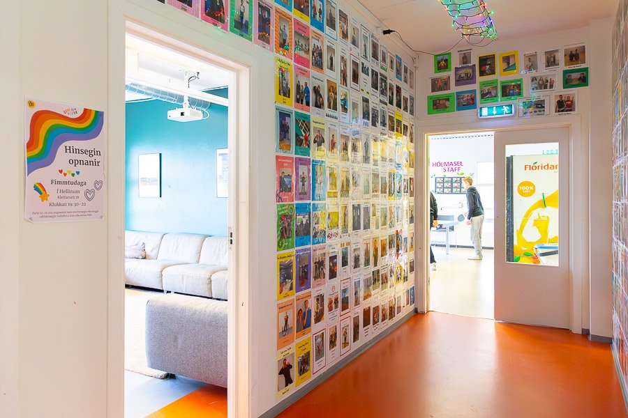 Hallway decorated with pictures of young people. View into the lounge and room with a ping-pong table.