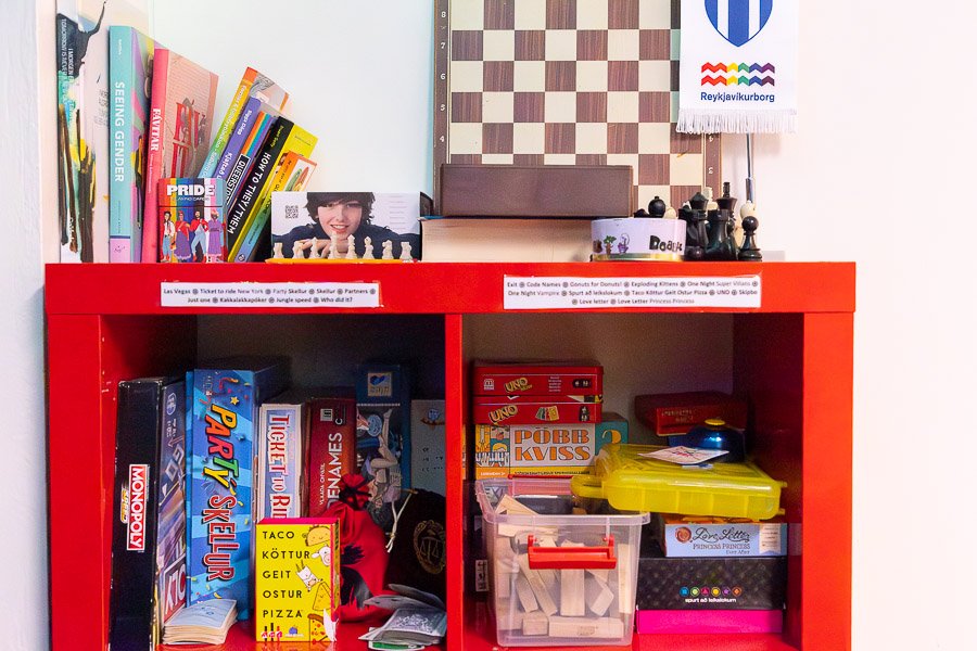 Red shelf with various games and chess sets.
