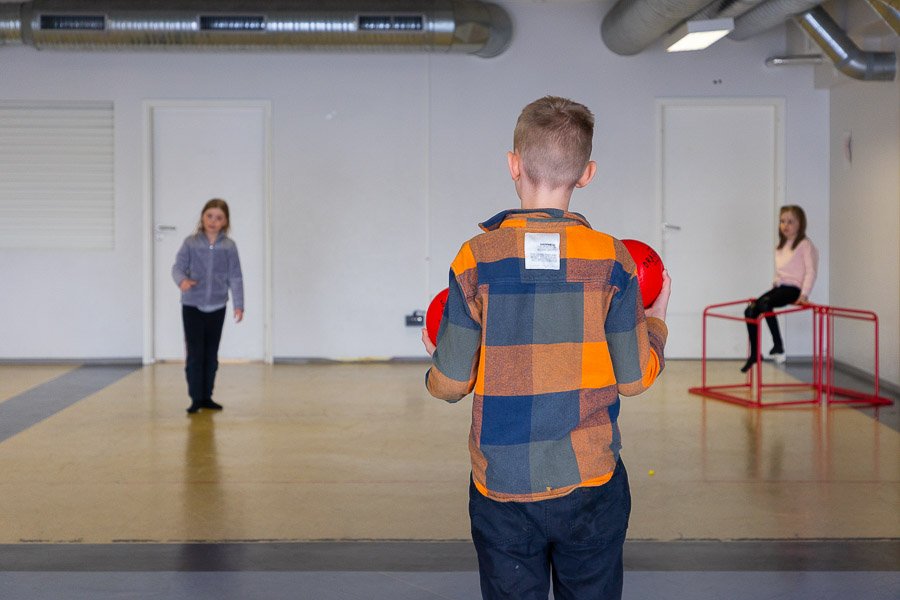 Children in the gymnasium playing ball games.
