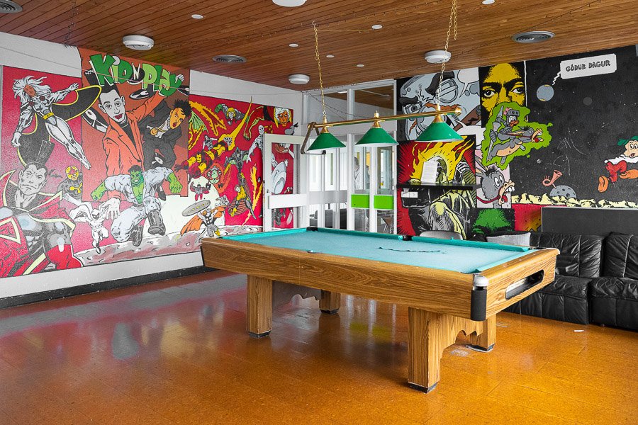 A room richly decorated with various figures on the walls and a pool table.