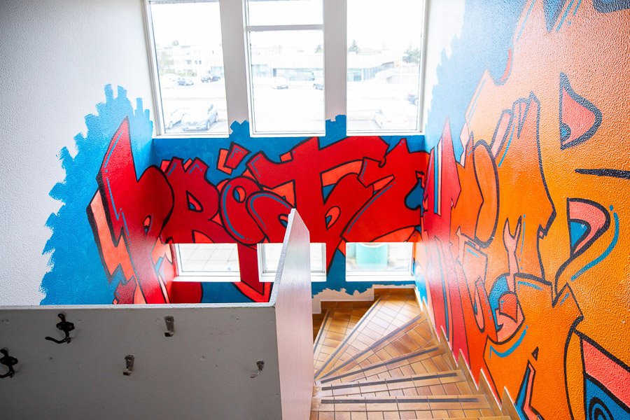 A stairway decorated with red and orange letters spelling out Þróttheimar.
