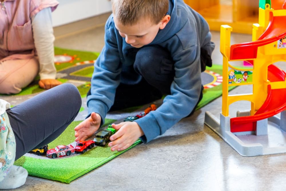 Children playing with cars and a race track.