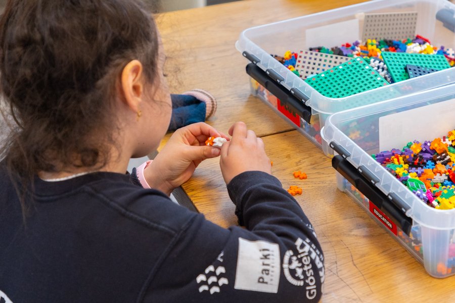 A child sits at a table playing with blocks.