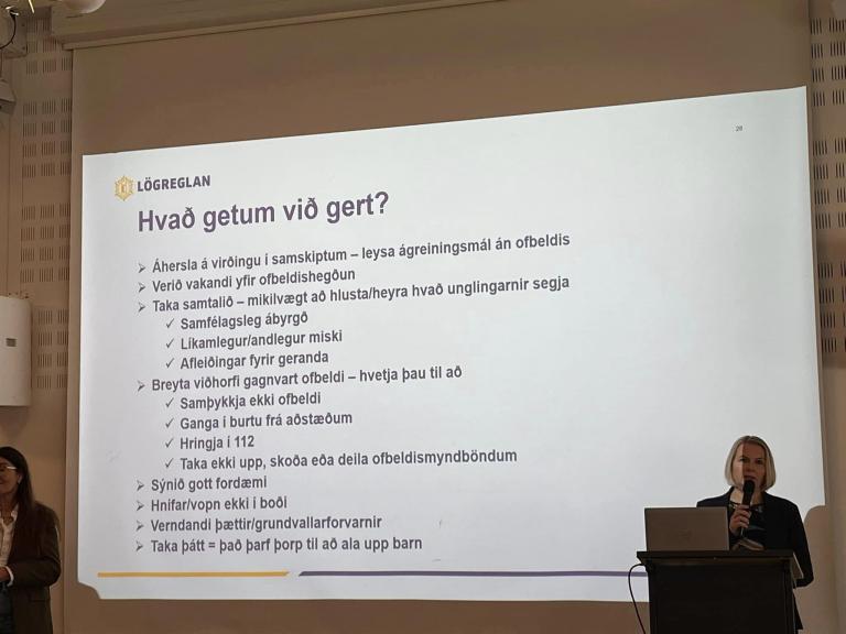 Frá vinnustofu í Valsheimili um börn í viðkvæmri stöðu. Glæra sem á stendur Hvað getum við gert? og kona í púlti að ræða efni glærunnar