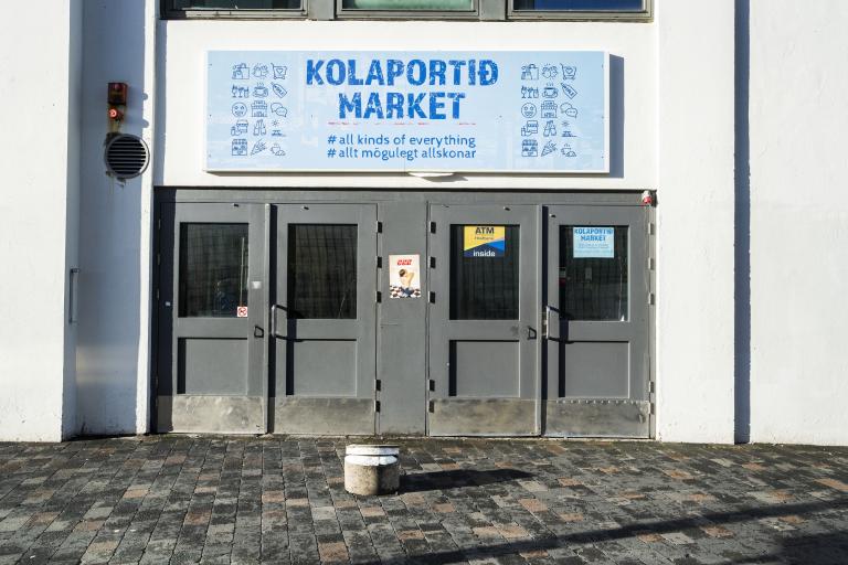 Side entrance to Kolaportið. Gray door with a sign above reading "Kolaportið market"