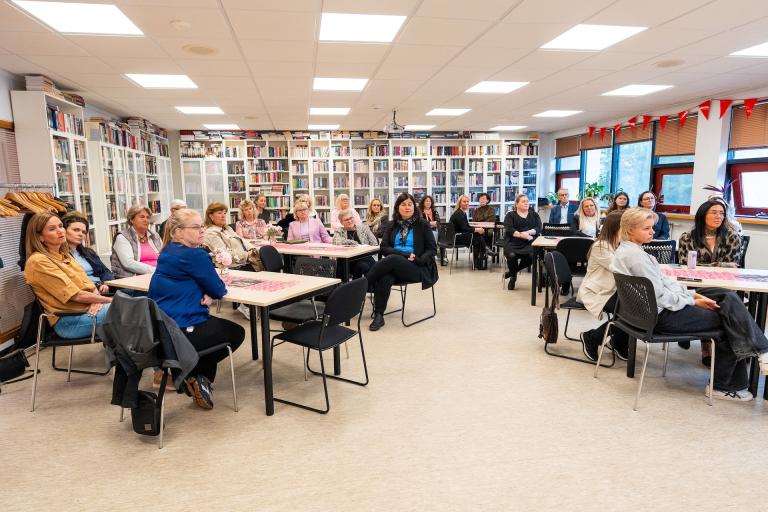 Attendees listen to a presentation at TINNA Aid's anniversary celebration at Gerðuberg. 