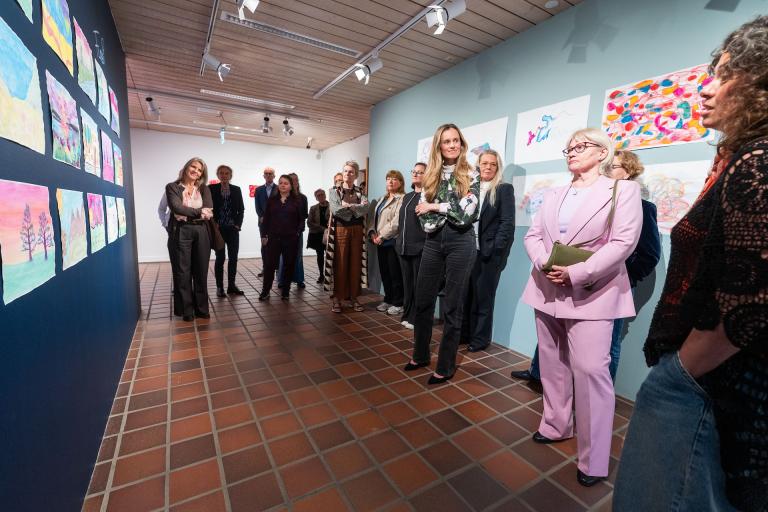 Visitors view works at the TINNA Aid fine arts exhibition in Gerðuberg.