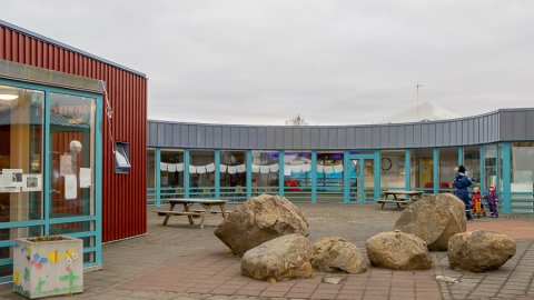 Hús leikskólans Lyngheima. Stórir grjóthnullungar í forgrunni.