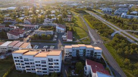 Loftmynd af Breiðholti, borgin og sólarlag í baksýn