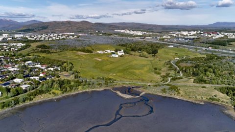 Aerial photo showing Keldur area, sea, grass, trees, buildings.