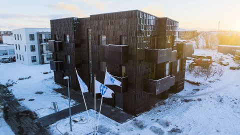 Drónamynd af íbúðakjarnanum á Háteigsvegi 59, fánar Reykjavíkurborgar blakta fyrir framan. 
