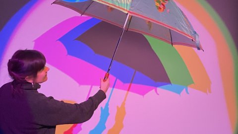 Students explore artistic expression using colors and an umbrella.