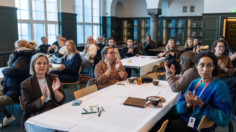 Fá málþingi um öryggi hinsegin fólks í Safnahúsinu 29.okt 2025. Fólk við borð í sal.