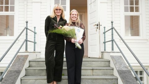 Borgarstjóri ásamt ungri konu með blóm á tröppum Höfða