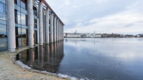 Ráðhúsið, sjónarhorn frá Tjarnargötu. Fyrir miðju má sjá Fríkirkjuna og Hallgrímskirkju, Tjörnin í forgrunni, Ráðhúsið til vinstri. Logn.